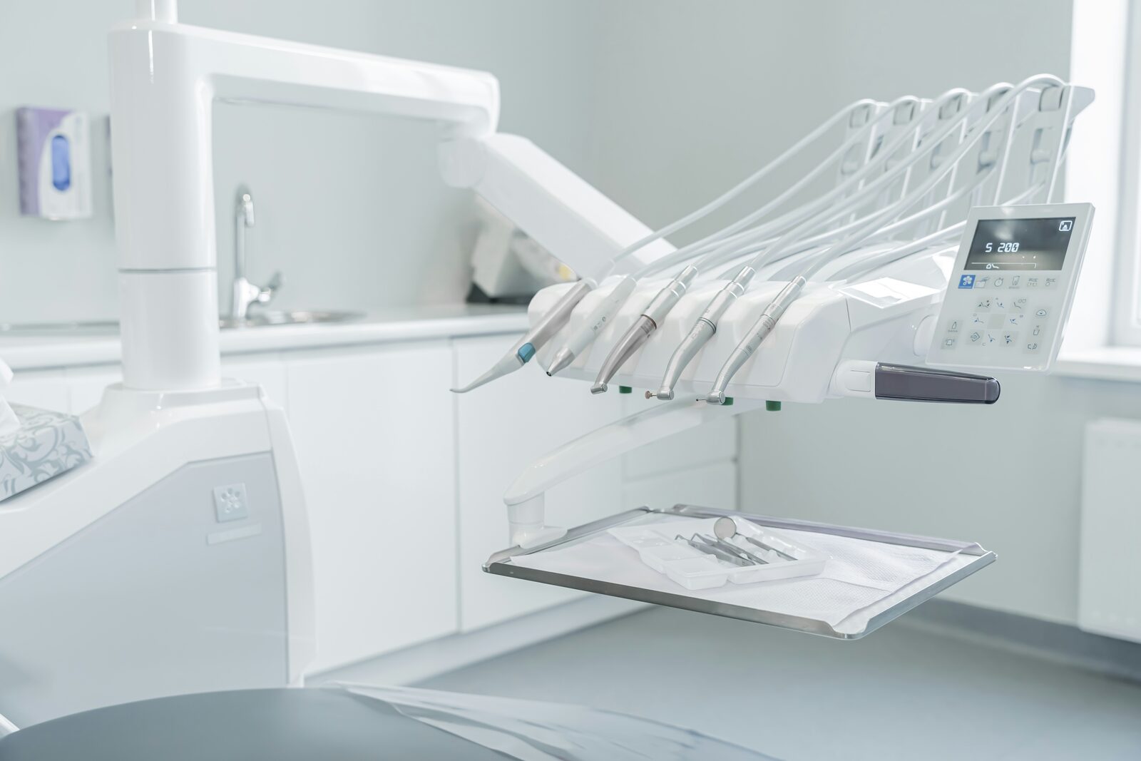 Clean, modern dental office with treatment chair and instruments.